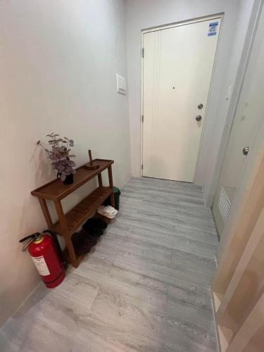 a hallway with a table and a white door at Affordable Minimalist Staycation Altaraza in Sapang Alat