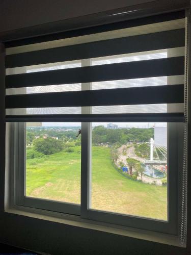 a window with a view of a green field at Affordable Minimalist Staycation Altaraza in Sapang Alat