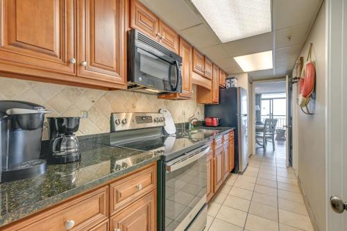 a kitchen with wooden cabinets and a stove top oven at Oceanfront Balcony Resort Condo in Myrtle Beach in Myrtle Beach