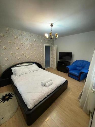 ein Schlafzimmer mit einem Bett und einem blauen Stuhl in der Unterkunft Casa din povesti in Crasna din Vale