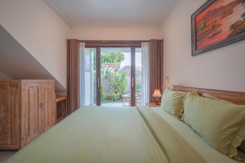 a bedroom with a large bed and a sliding glass door at Titeng Guest House - Comfortable studio in amazing location near Potato Head and the beach in Seminyak