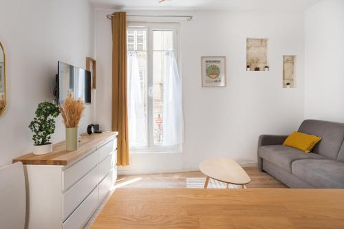 un salon avec un canapé et une télévision dans l'établissement Le Nid - Charmant Studio au Cœur d'Arles, à Arles