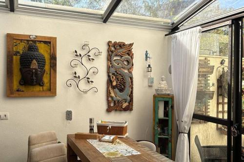 Un comedor con una mesa y algunas decoraciones en la pared. en Seu Lar fora de casa, em Curitiba, en Curitiba