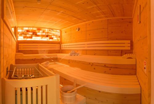 a sauna with wooden walls and benches in a cabin at Pension Rosenhügel in Neustift im Stubaital