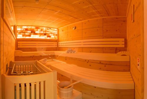 - un sauna avec des murs en bois et des bancs dans une cabine dans l'établissement Pension Rosenhügel, à Neustift im Stubaital