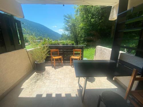 d'une terrasse avec des chaises et une table offrant une vue. dans l'établissement La belle Agathe, Vercors, à Le Guâ