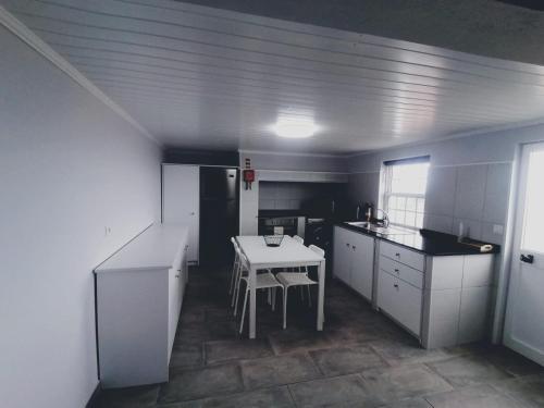 a kitchen with a table and a white table in it at Casas do Baleeiro - Casa da Vinha in Cais do Pico