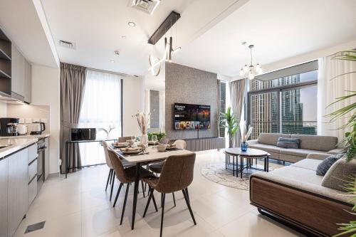 a kitchen and living room with a table and a couch at City Views, Pool & Gym Near Iconic Burj Khalifa in Dubai