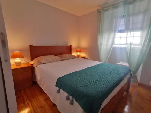 a bedroom with a large bed and a window at Casas do Baleeiro - Casa da Vinha in Cais do Pico