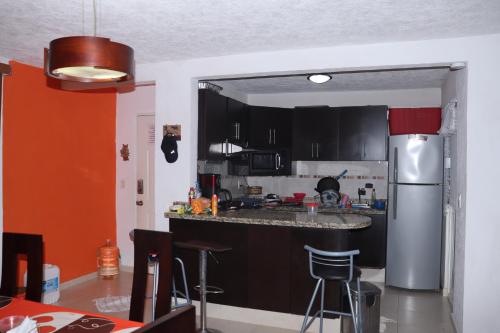 a kitchen with black cabinets and a stainless steel refrigerator at depto relajante Diamante in Acapulco