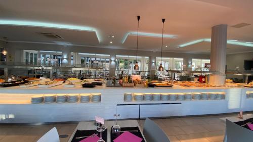 a restaurant with a large kitchen with tables in it at Hotel Apartamentos Solimar in Calafell