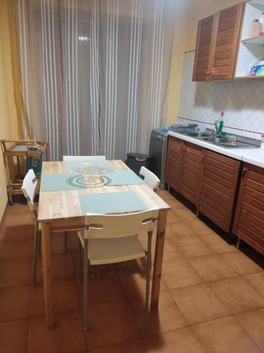 a kitchen with a table with chairs and a sink at Nucifora's House in Riposto