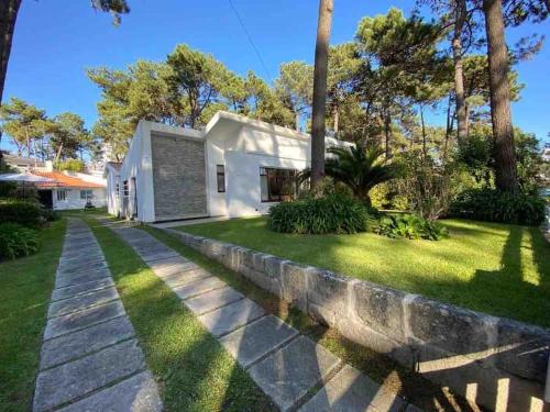 a house with a stone retaining wall next to a yard at Coral Beach House in Viana do Castelo