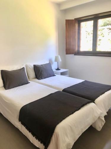 een groot bed in een slaapkamer met een raam bij Coral Beach House in Viana do Castelo