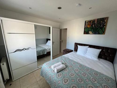 une chambre avec un grand lit et un miroir dans l'établissement Appartement moderne à Villiers-le-Bel - 35 m² - Pour 4 personnes., à Villiers-le-Bel