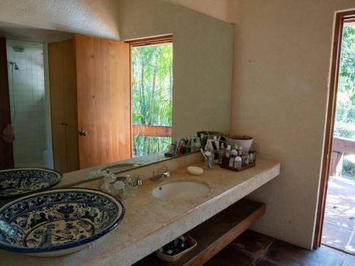 a bathroom with two sinks and a mirror at El Zapote House With orchard and pool in Malinalco in Malinalco