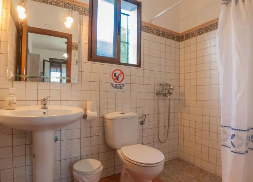 a bathroom with a toilet and a sink and a mirror at Comfortable Villa in Algodonales with Private Pool in Algodonales