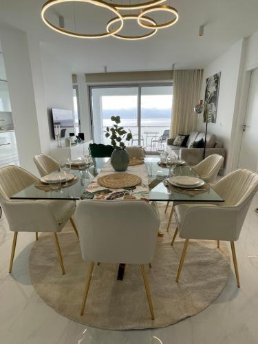 a dining room with a glass table and chairs at Suites Avenue Azores in Horta