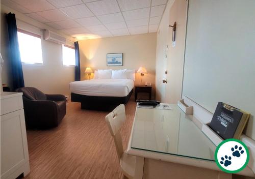 a hotel room with a bed and a glass table at Hôtel Aquamer in Carleton sur Mer