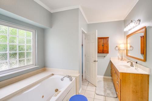 a bathroom with a tub and a sink and a window at Beautiful Home Less Than 1 Mi to Hot Springs National Park in Hot Springs