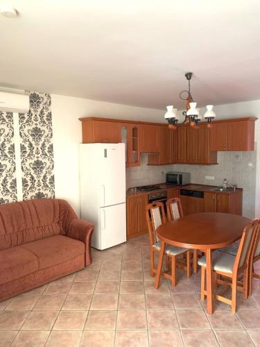 a living room with a table and a kitchen with a couch at Zámor 10 Apartmant in Keszthely