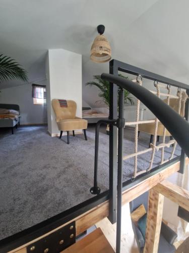 a living room with a staircase and a chair at Zakątek nad Świdrem in Otwock