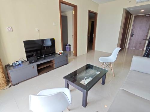 a living room with a tv and a table and chairs at MESA Thamrin City Apartments at Nagoya with Netflix & Pick Up Service in Nagoya