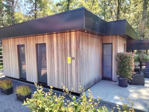 a small wooden building with a black roof at Theressa - Free Wifi en Netflix in Zutendaal