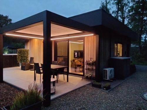 a black pavilion with a dining table and a patio at Theressa - Free Wifi en Netflix in Zutendaal