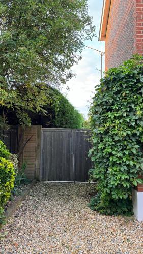 a privacy fence in front of a house at Bosham - private and self-contained double garden room in Chichester