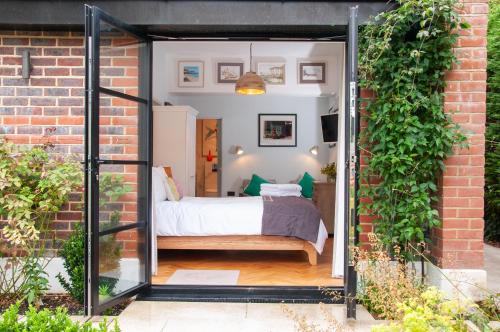 a room with a bed in a brick building at Bosham - private and self-contained double garden room in Chichester