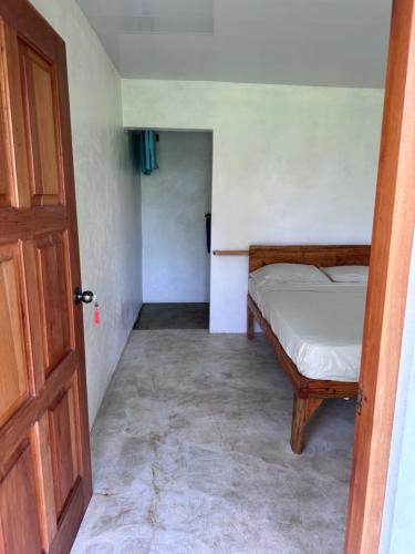 a small bedroom with a bed and a door at Silversands Retreat SA in Corn Island