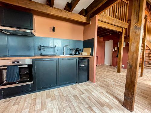 a kitchen with blue cabinets and a wooden floor at Casa Andrea - Hypercentre & climatisation in Metz