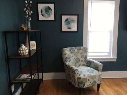 a living room with a chair and a window at Center Midtown WalkUp in Omaha