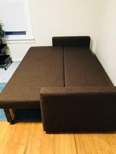 a bed in a room with a wooden floor at Center Midtown WalkUp in Omaha
