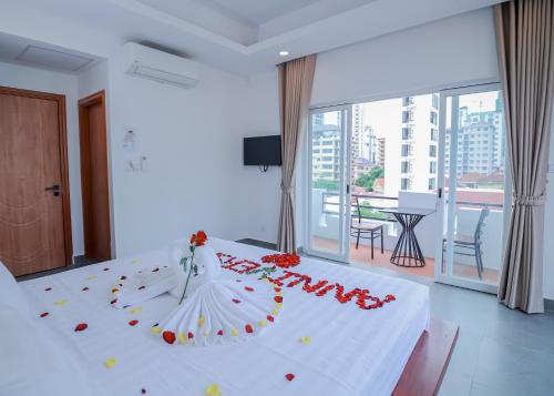 a bedroom with a white bed with roses on it at Bliss & Beats Hostel in Phnom Penh