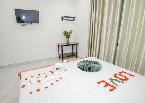 a hotel room with a bed with a flower arrangement on it at Bliss & Beats Hostel in Phnom Penh