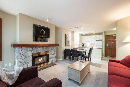 a living room with a fireplace and a dining room at The Aspens by Outpost Whistler in Whistler