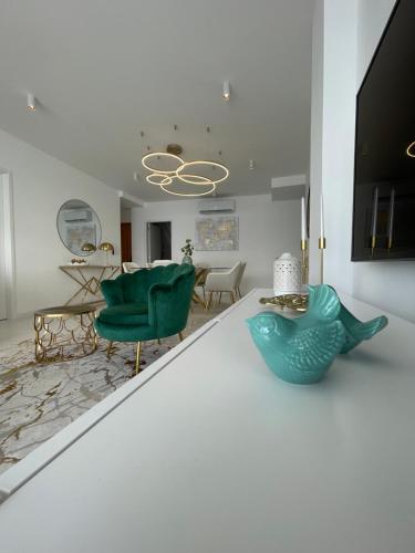 a living room with a green chair and a table at Suites Avenue Azores in Horta