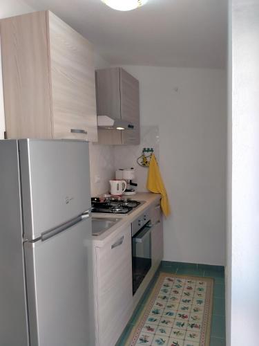 a kitchen with a refrigerator and a stove top oven at La casa di nonna Bonaria in Baunei
