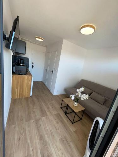 un salon avec un canapé et une table dans l'établissement Studio au centre de Canet Plage 1min à pied de la plage, à Canet