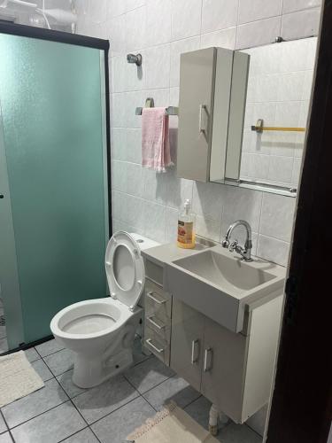 Un baño con inodoro, lavabo y ducha. en Ap Canto do Forte com Wi-Fi, TV e varanda, en Praia Grande