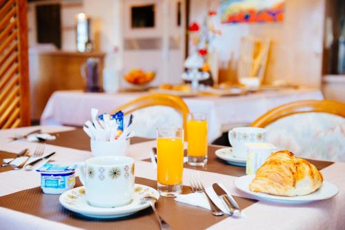 een tafel met een ontbijt van croissants en jus d'orange bij Plage des Pins in Argelès-sur-Mer