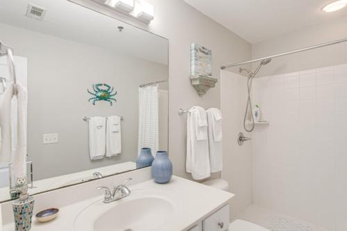 a white bathroom with a sink and a mirror at Darien Condo with Boat Dock Access Walk to Downtown in Darien