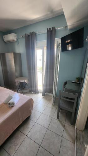 a bedroom with a bed and a table and a chair at Andreas Studios in Mastichari