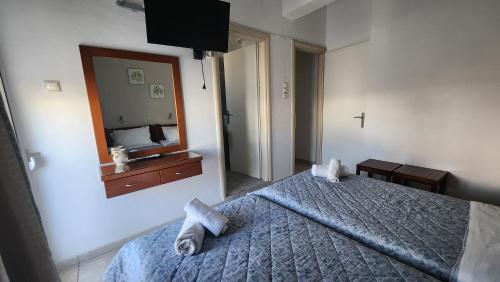 a bedroom with a bed and a mirror at Andreas Studios in Mastichari
