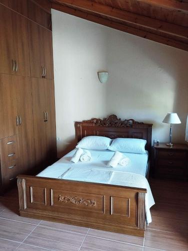 a bed with a wooden frame in a bedroom at Το Αρχοντικό της Λενιώς in Taxiárkhis