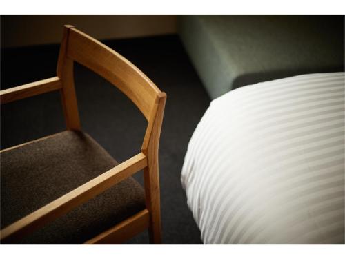 une chaise en bois à côté d'un lit à côté d'un matelas blanc dans l'établissement HOTEL SLOW VILLAGE - Vacation STAY 66834v, à Hagyū