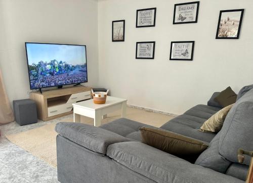 a living room with a couch and a flat screen tv at Sweet Home in Miranda do Douro