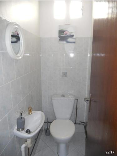 a white bathroom with a toilet and a sink at Chez Tatie Juju in Sainte-Anne
